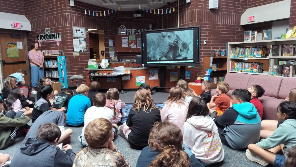 school children watching film during author visit